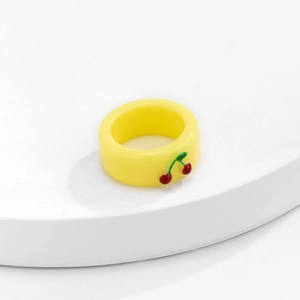 Detail eines gelben Harzrings mit kleinen 3D-Kirsch-Ornamenten auf der breiten Schiene