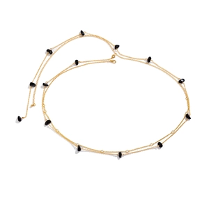 Detail of layered gold body chain featuring polished black stones and clear rhinestones