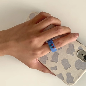 Detailansicht eines blauen Harzrings mit 3D-Kirschmotiv, getragen an der Hand