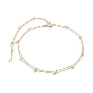 Close-up of gold body chain with pink stone accents and sparkling rhinestones