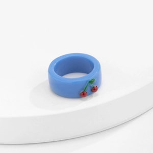 Nahaufnahme eines blauen Harzrings mit süßem 3D-Kirschdekor im Y2K-Stil
