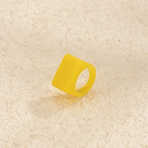 Vue détaillée d'une bague en résine jaune vif avec un design géométrique carré