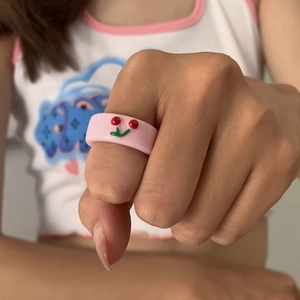 Detailaufnahme eines rosa Harzrings mit Kirschmuster am Finger eines Modells