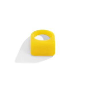 Détail d'une bague géométrique en résine jaune vif avec une large surface plane rectangulaire