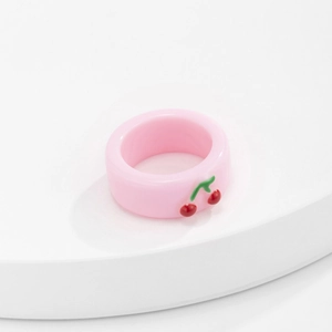 Detail eines rosa Harzrings mit 3D-Kirschakzent auf einem weißen Präsentationsständer