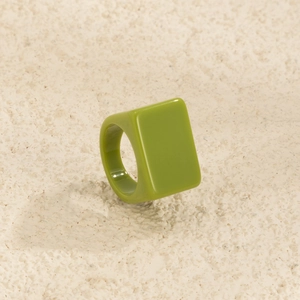 Vue détaillée d'une bague rectangulaire en résine vert avocat avec une finition lisse et large