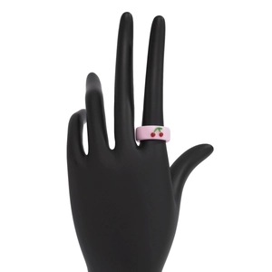 Detail eines hellrosa Harzrings mit Kirschmotiv auf einem schwarzen Handdisplay