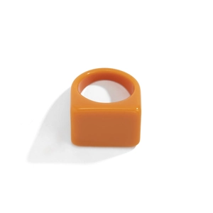 Vue macro d'une bague en résine orange vif avec plateau carré et anneau large design