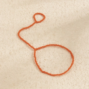 Dettaglio del bracciale ad anello fatto a mano con perline color arancione vivace