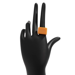 Vue détaillée d'une bague moderne en résine orange sur un support main noir mat