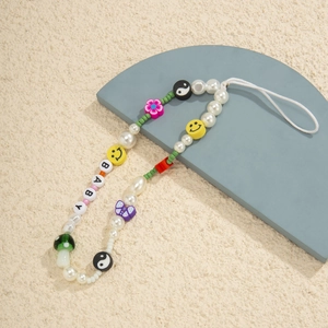 Macro detail of a colorful beaded phone strap with pearls, mushroom and BABY letters