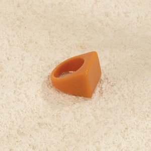 Vue détaillée d'une bague géométrique en résine orange avec un design carré moderne