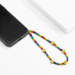 Détail de la dragonne de téléphone en perles colorées faites main avec des smileys jaunes