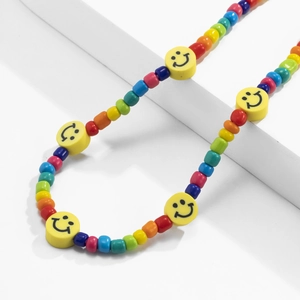 Detailed macro view of colorful rainbow beads and yellow smiley faces on a phone strap