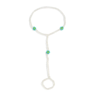 Detail of bohemian white beaded hand chain with turquoise daisy floral accents