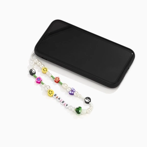 Detail of colorful beaded phone strap with pearls and BABY letter charms on a phone