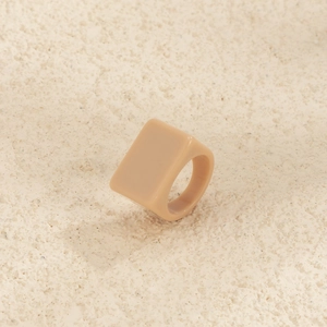 Vue détaillée d'une bague en résine beige épaisse au design géométrique minimaliste