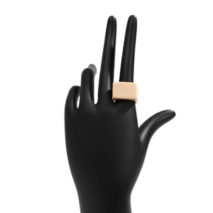 Gros plan d'une large bague géométrique en résine beige mate portée sur une main noire