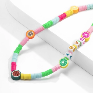 Macro detail of colorful fruit beads and BABY letter beads on a minimalist phone strap