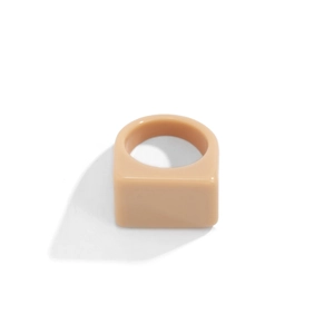 Vue latérale macro d'une bague carrée minimaliste en résine beige avec finition mate