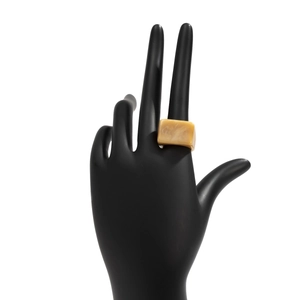 Détail d'une bague rectangulaire en résine ambrée avec texture marbrée sur un mannequin
