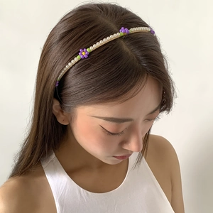 Minimalist pearl headband with purple and green beaded flowers worn by a model