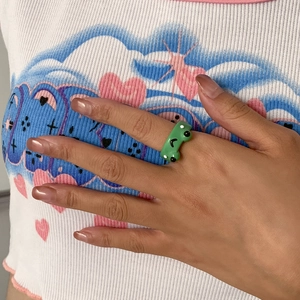 Detailansicht eines grünen Froschrings aus Harz am Finger mit niedlichem 3D-Tierdesign
