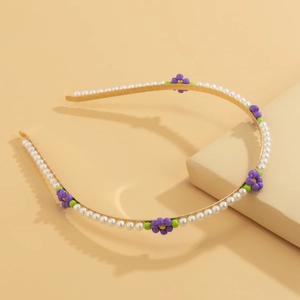 Elegant floral headband featuring faux pearls and colorful daisy accents on a gold base