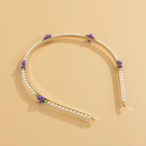 Detailed macro of golden floral headband with white pearls and small beaded daisies