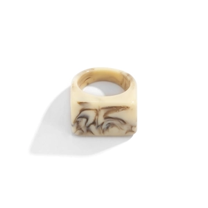 Vue détaillée d'une bague en résine crème avec texture marbrée brune et sommet plat carré