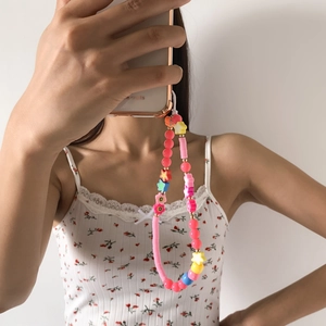 Detail of colorful beaded phone strap with macaron clay disks, smiley beads and stars