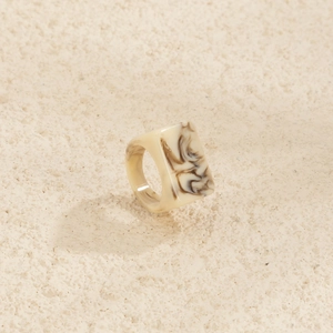 Détail de la bague rectangulaire en résine avec motifs de marbre beige et marron