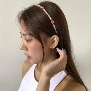 Detail of floral beaded headband with white pearls and colorful flower accents
