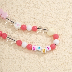Detailed macro view of colorful acrylic beads with heart and star shapes and BABY letters