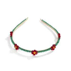 Detail of gold metal headband with green beads and yellow-red crystal flower clusters