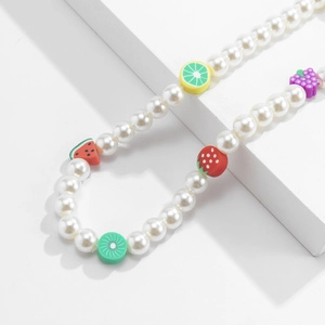 Detail of beaded phone strap featuring white faux pearls and colorful clay fruit charms