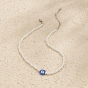 Detalle del collar de cuentas de colores con colgante letra R y cierre de langosta