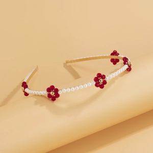 Detail of vintage gold headband with white pearls and red crystal beaded flowers