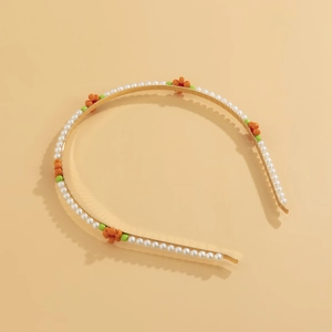 Detail of floral beaded headband with white pearls and orange daisy charms on gold wire