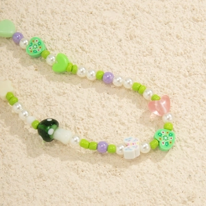 Detail of colorful Y2K beaded strap with flower hearts and faux pearls in sunlight