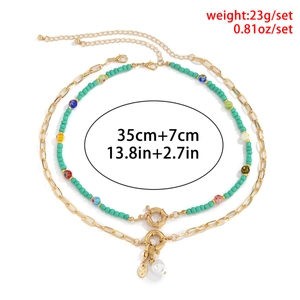 Detail van kleurrijke kralenketting met gouden munt en barokke parel met afmetingen