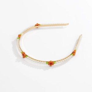 Detail of thin gold headband with white faux pearls and handmade beaded orange flowers