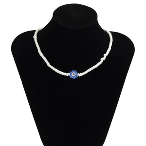 Detalle de collar de cuentas acrílicas blancas con colgante de flor azul y la letra R