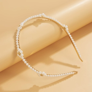 Close-up of gold daisy headband featuring white pearls and elegant floral weave