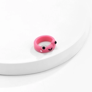Nahaufnahme eines 3D-Froschrings aus rosa Harz mit großen Augen und Smiley-Detail