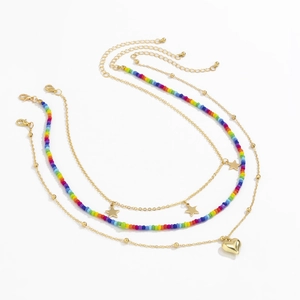 Detail van bohemien gelaagde kralenketting met gouden sterren en hartjes hanger