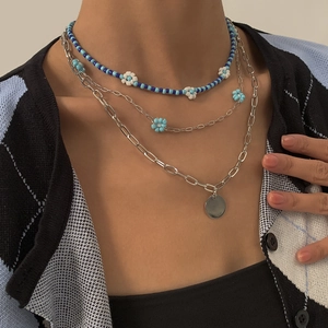 Detail van gelaagde bohemian ketting met kralen en paperclip-schakels