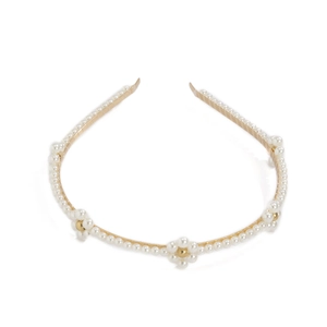 Detail of gold metal headband featuring white faux pearls in elegant floral patterns