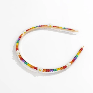 Close-up of colorful beaded daisy headband with gold metal base and macaron beads