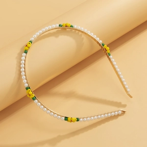 Detail of gold metal headband with white faux pearls and colorful beaded daisy flowers